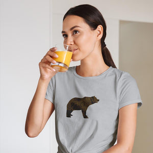 woman drinking orange juice wearing brown bear t-shirt